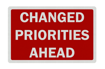 Photo realistic metallic reflective 'change in priorities' sign, isolated on pure white. Business / political metaphor